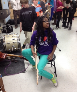 Young bassist listens intently as we compose a song to be performed in music and paint