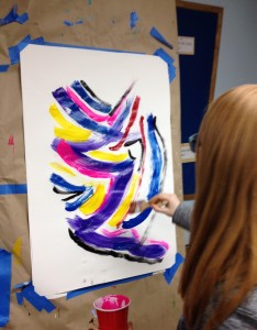 Applewild Seventh grader takes her turn in a collaborative visual jazz painting while classmates and IENE personnel perform some improvised jazz